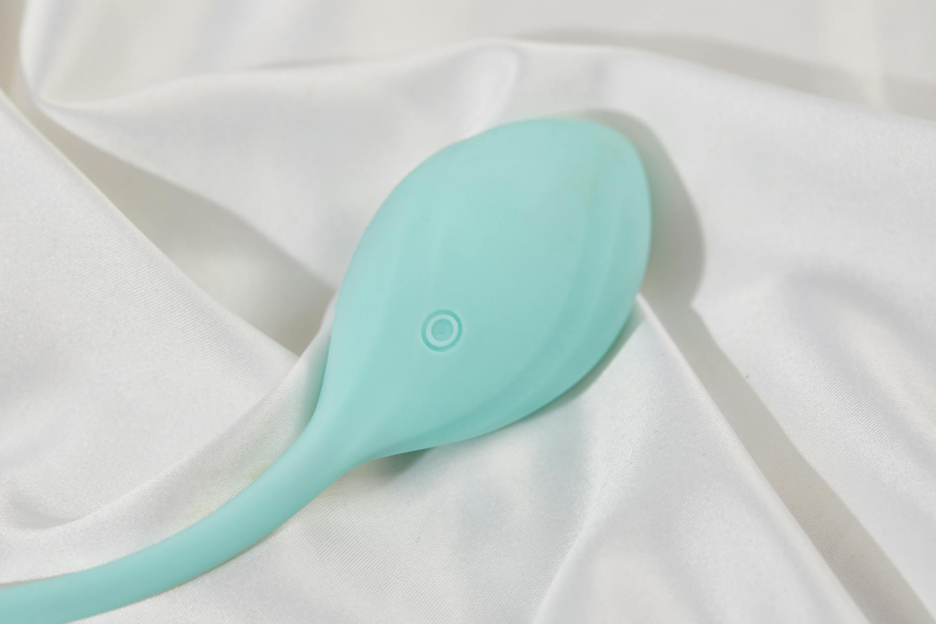 A blue silicone clitoral vibrator held in hand against a solid purple background, symbolizing self-care and reconnecting with pleasure