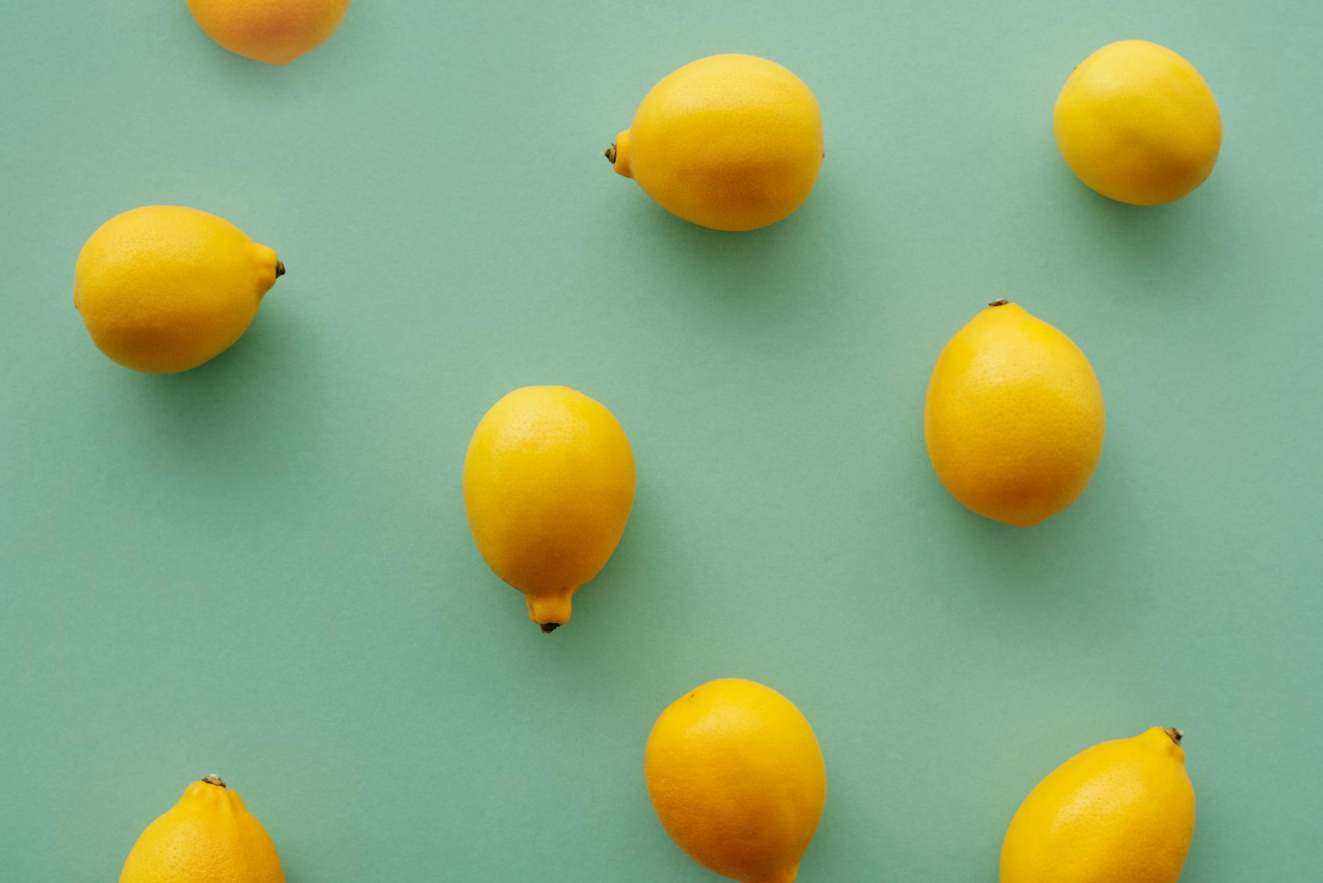 Bright yellow lemons arranged on a pastel green background, symbolizing renewal and fresh beginnings