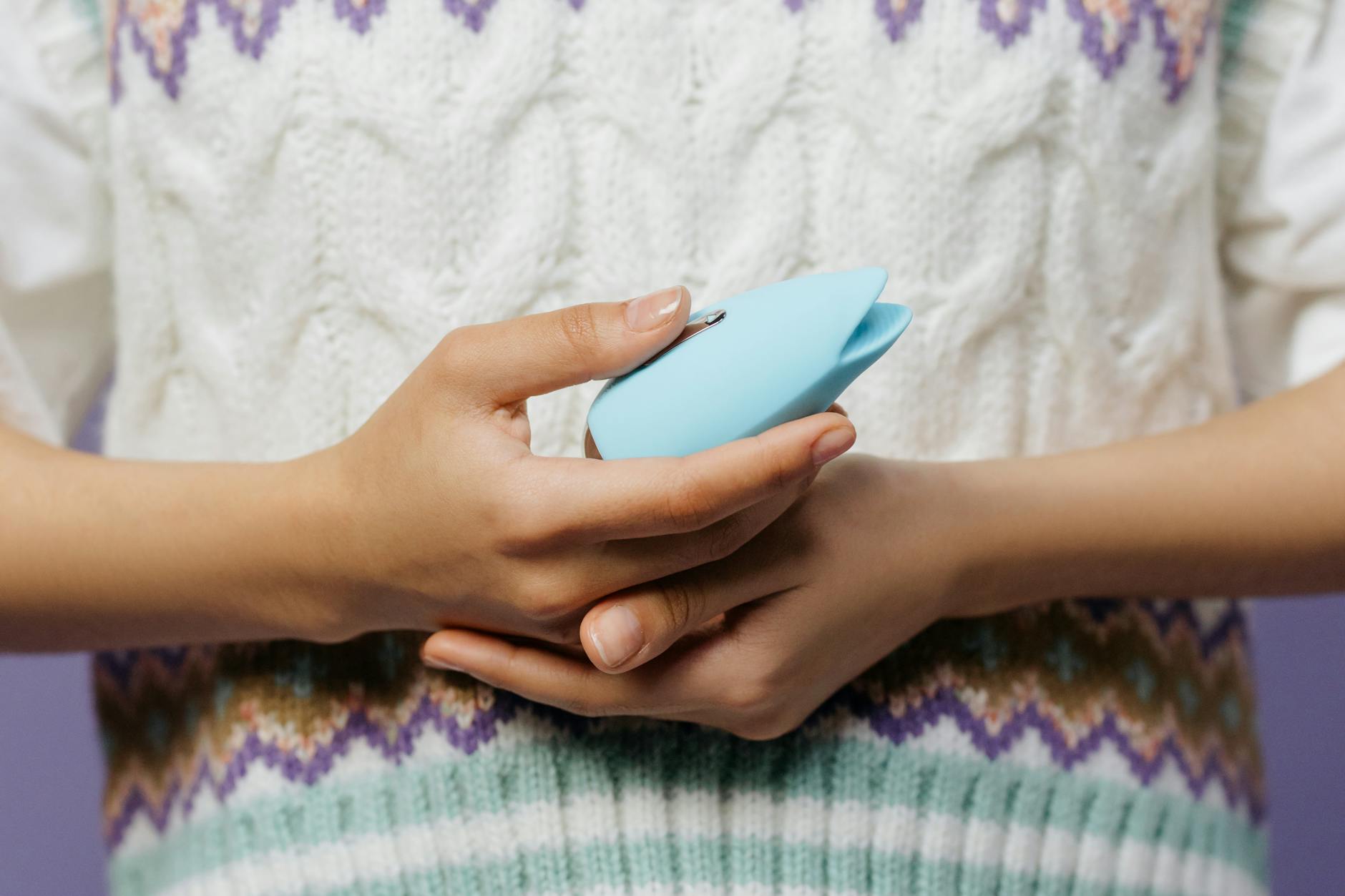 Close-up of hands holding a personal massager, representing gentle reconnection with pleasure after loss.
