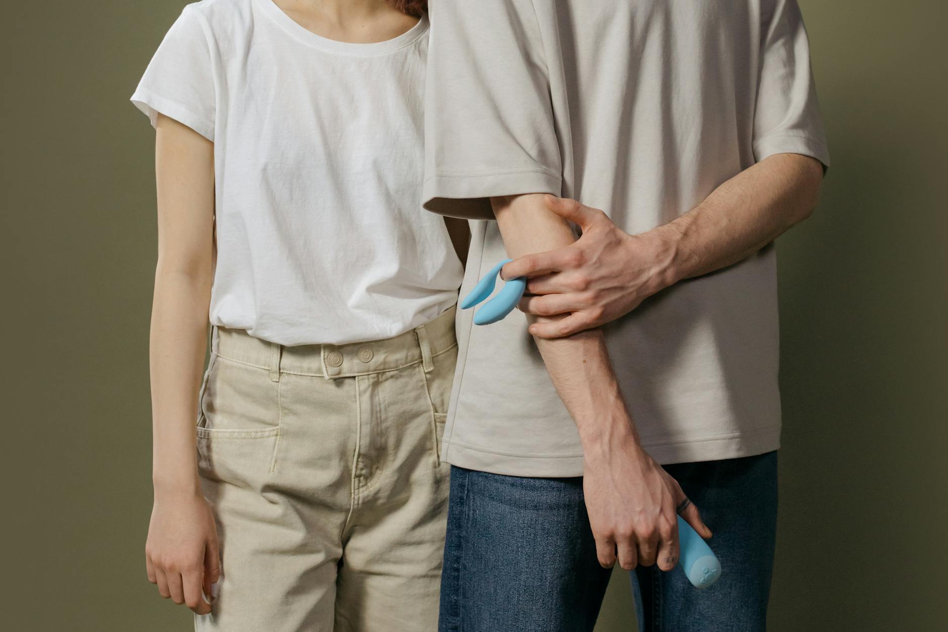 A couple holding a modern blue vibrator together, representing shared intimacy and time-efficient pleasure