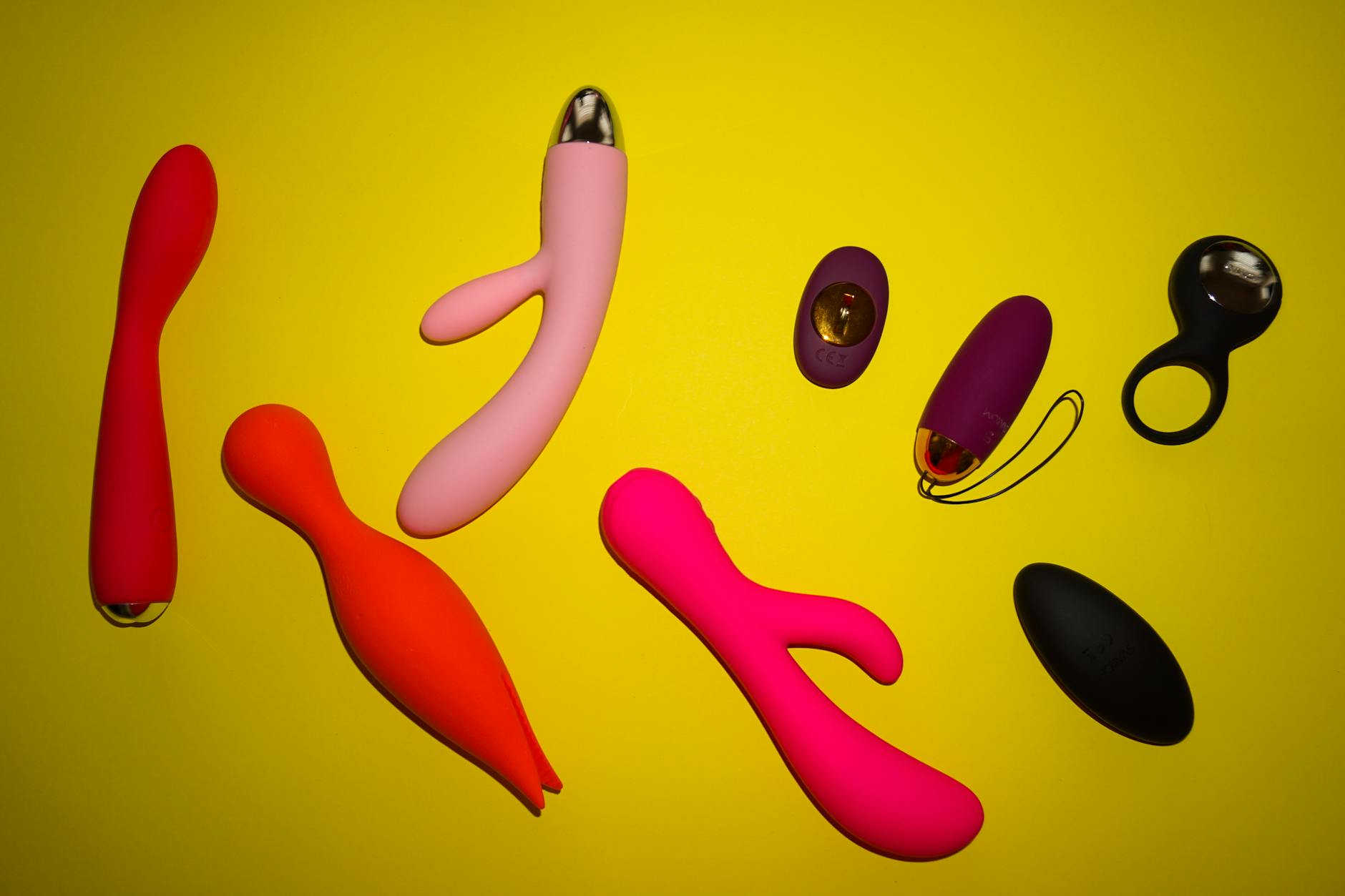 Vibrant collection of colorful clitoral vibrators on bright yellow background