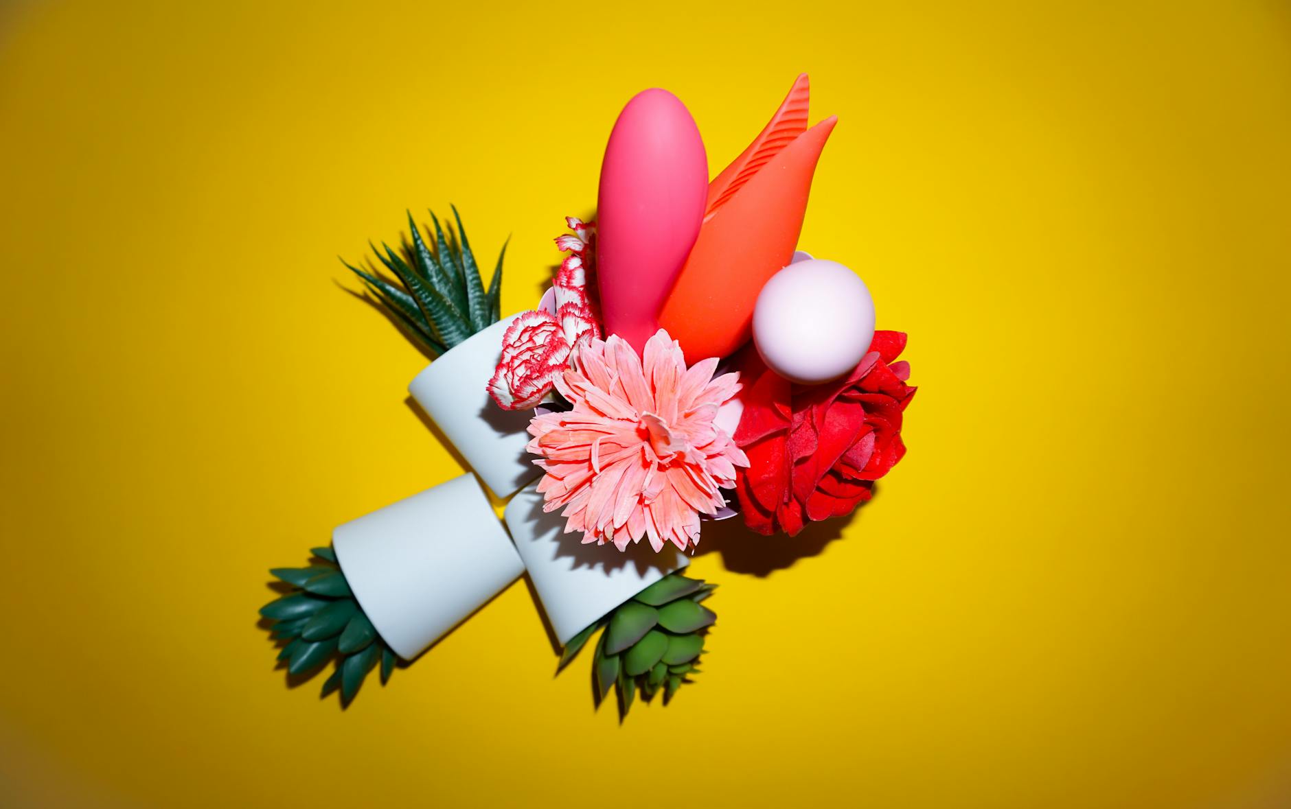 Vibrant collection of colorful clitoral vibrators on a bright yellow surface, including lemon-shaped designs.